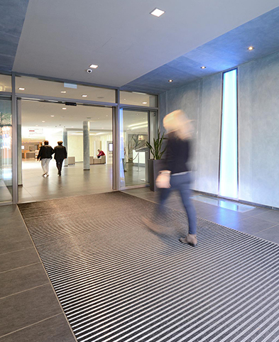 Frau geht durch den Eingangsbereich des EVK Mettmann ins Foyer des Krankenhauses.