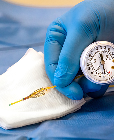 Arzt des Gefäßzentrums mit einem Stent in der Hand.