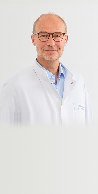Porträtbild von Chefarzt Dr. med. Knaust auf grauem Hintergrund.