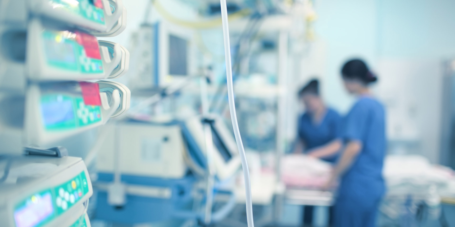 Zwei Pflegefachkräfte bei Patienten auf Intensivstation.