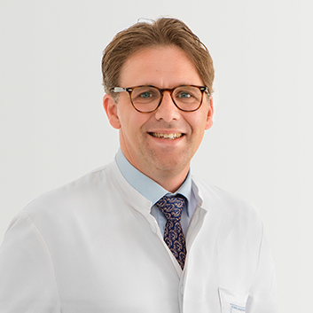 Porträtbild vom Chefarzt Innere Medizin – Prof. Dr. med. Christian Berg auf grauem Hintergrund.