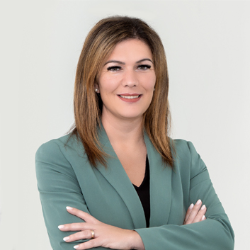 Porträtbild von Jessica Llerandi Pulido – Geschäftsführerin des EVK Mettmann auf grauem Hintergrund.