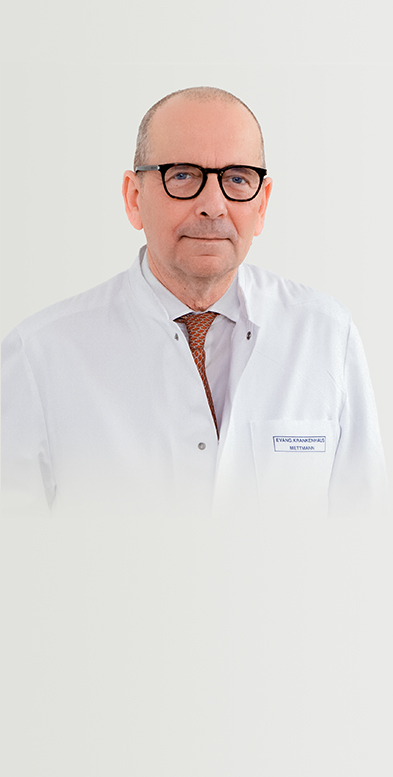 Porträtbild von Chefarzt Dr. med. Huberts auf grauem Hintergrund.