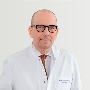 Porträtbild vom Chefarzt der Gefäßchirurgie Dr. med. Huberts auf grauem Hintergrund.