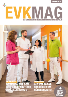 Titelbild des EVKMAG – Klinikmagazin aus dem EVK Mettmann – Ausgabe 01.2025. Es zeigt ein Gruppenbild von einem Teil des Teams der Geriatrie, die sich auf dem Flur der Station unterhalten.